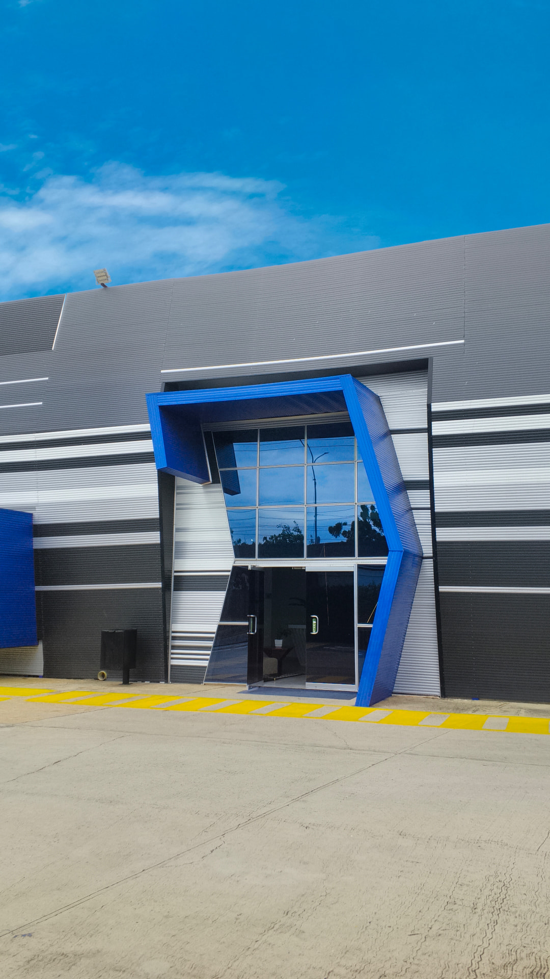 Acceso principal con estructura arquitectónica azul de la planta Maier